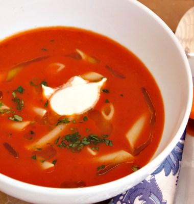 Serveringsklar tomatsuppe med pasta og creme fraiche